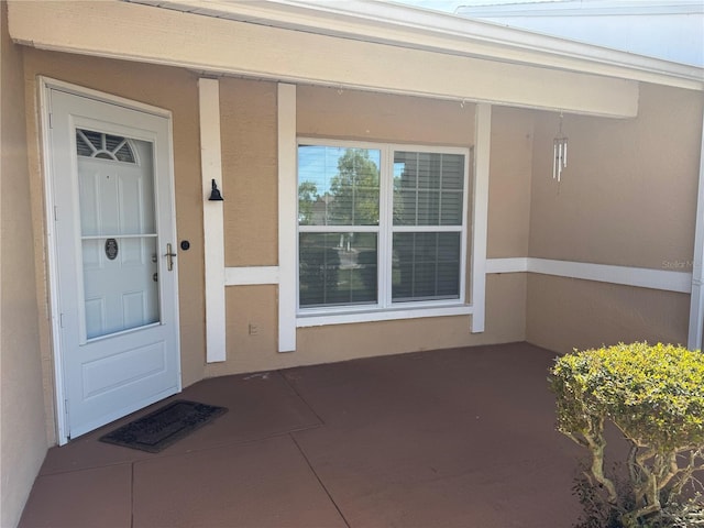 view of exterior entry with stucco siding