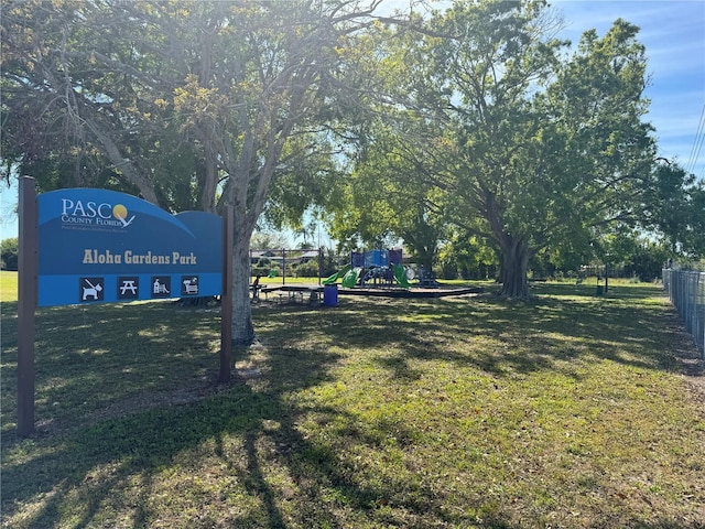 surrounding community with a yard, fence, and playground community