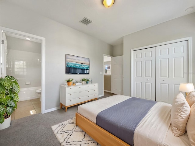 bedroom with baseboards, visible vents, ensuite bath, a closet, and light carpet