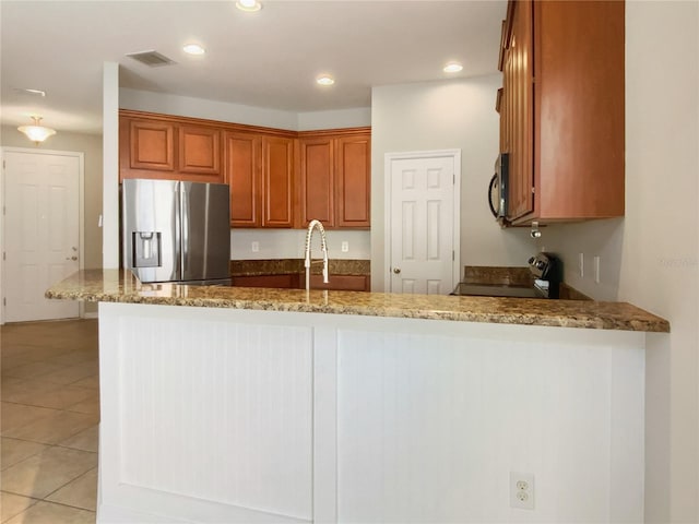 kitchen with visible vents, light tile patterned floors, appliances with stainless steel finishes, stone countertops, and a sink