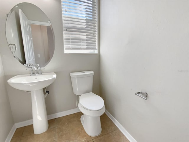 bathroom featuring tile patterned flooring, toilet, and baseboards