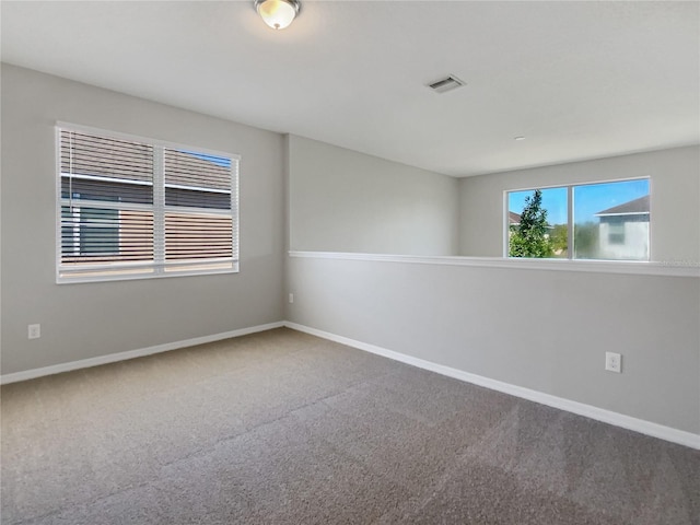 spare room featuring visible vents, baseboards, and carpet floors