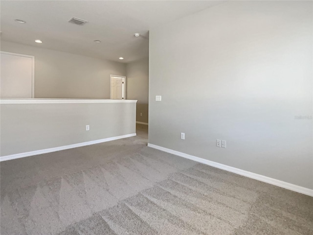 empty room featuring visible vents, recessed lighting, carpet flooring, and baseboards