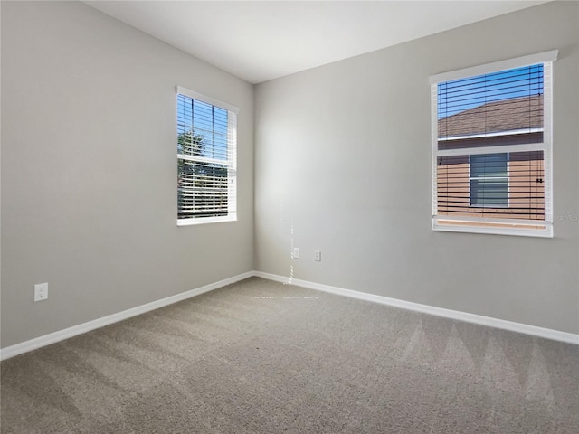 carpeted empty room with baseboards