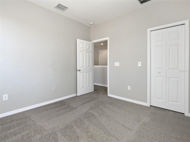 unfurnished bedroom with visible vents, carpet floors, baseboards, and a closet