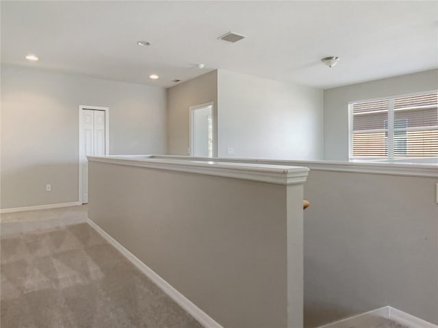 hall featuring recessed lighting, visible vents, baseboards, and light carpet