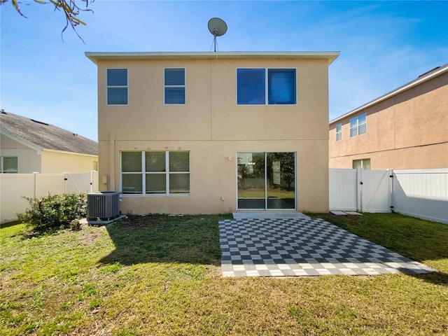 rear view of property with stucco siding, a lawn, a gate, central AC, and a fenced backyard