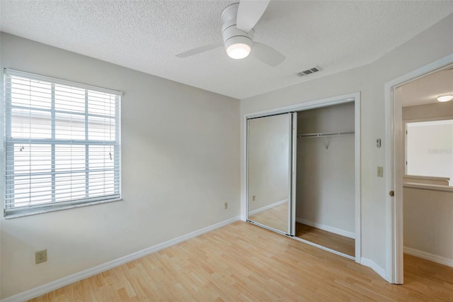 5014 Sterling Manor Dr, Tampa, FL 33647 - unfurnished bedroom with a textured ceiling, wood finished floors, a closet, baseboards, and a ceiling fan