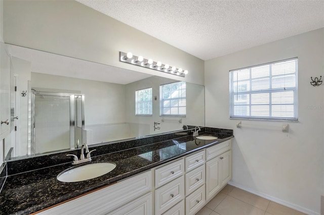 5014 Sterling Manor Dr, Tampa, FL 33647 - full bathroom featuring double vanity, a shower stall, tile patterned floors, a textured ceiling, and baseboards