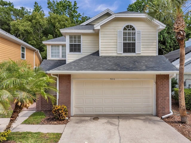 5014 Sterling Manor Dr, Tampa, FL 33647 - view of front facade featuring brick siding, roof with shingles, driveway, and a garage