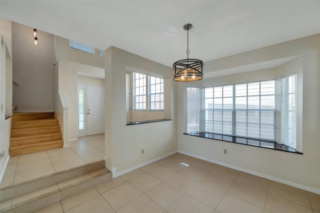 5014 Sterling Manor Dr, Tampa, FL 33647 - tiled empty room with healthy amount of natural light, stairs, a chandelier, and baseboards