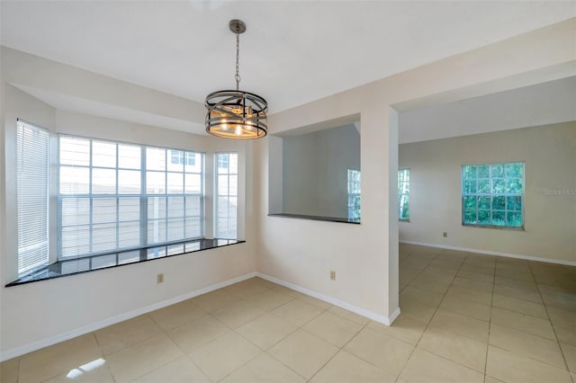 5014 Sterling Manor Dr, Tampa, FL 33647 - empty room featuring a chandelier, light tile patterned floors, and baseboards