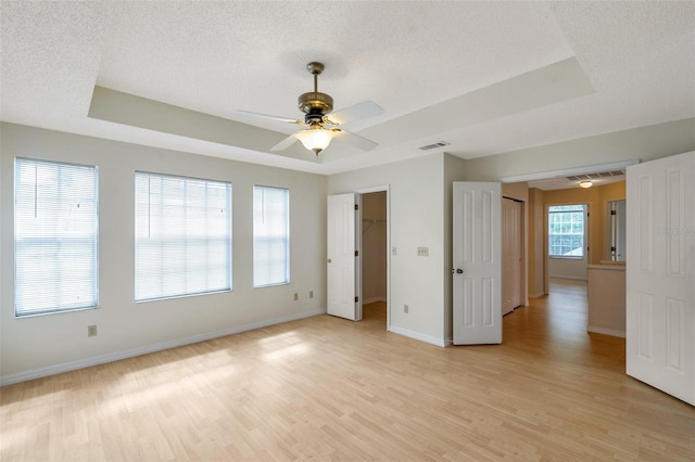 5014 Sterling Manor Dr, Tampa, FL 33647 - empty room with a raised ceiling, a textured ceiling, light wood-style floors, baseboards, and a ceiling fan