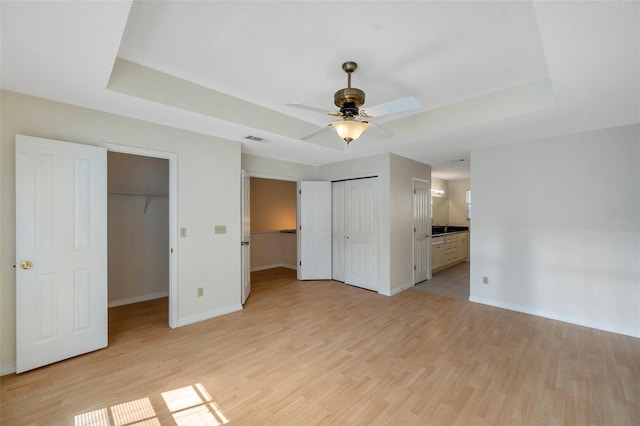 5014 Sterling Manor Dr, Tampa, FL 33647 - unfurnished bedroom with light wood-style floors, baseboards, and a raised ceiling