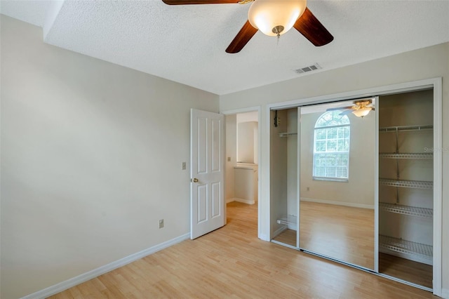 5014 Sterling Manor Dr, Tampa, FL 33647 - unfurnished bedroom featuring light wood-style floors, a closet, baseboards, and a textured ceiling