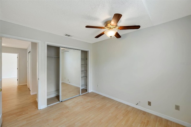 5014 Sterling Manor Dr, Tampa, FL 33647 - unfurnished bedroom with light wood finished floors, a closet, baseboards, a textured ceiling, and ceiling fan