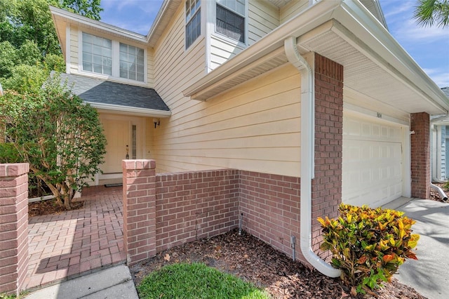 5014 Sterling Manor Dr, Tampa, FL 33647 - view of exterior entry featuring an attached garage, brick siding, and driveway