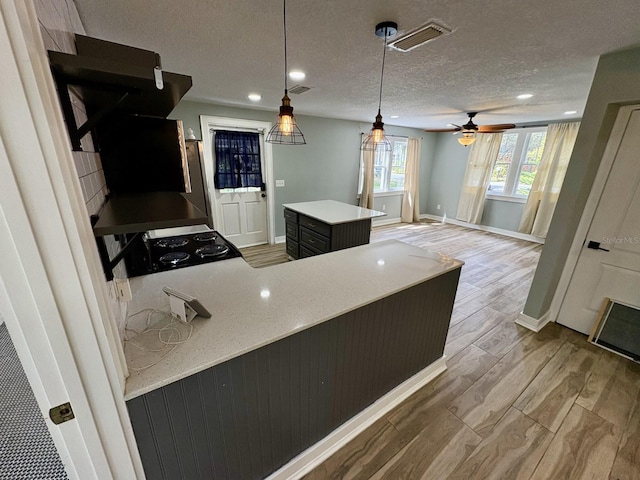 kitchen with visible vents, baseboards, black range oven, wood finished floors, and a textured ceiling