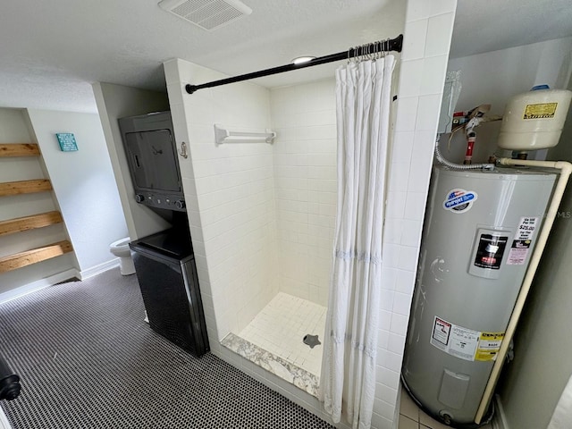 full bathroom with visible vents, a shower stall, baseboards, water heater, and a textured ceiling