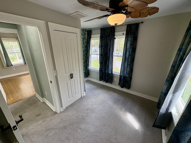 unfurnished bedroom featuring visible vents, baseboards, carpet floors, and a closet