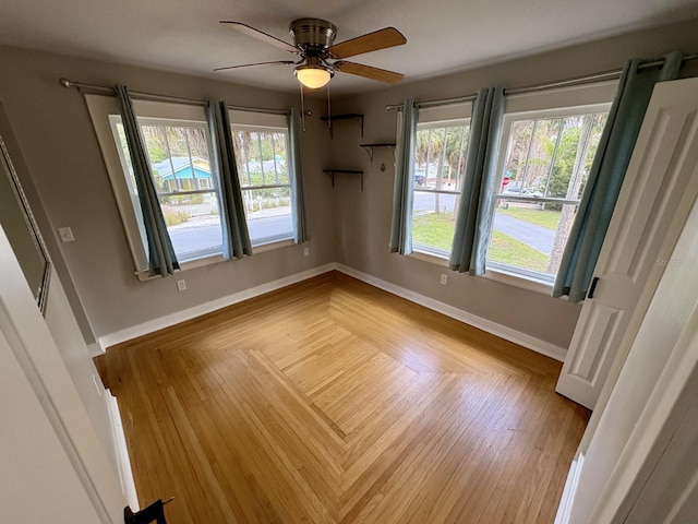 spare room featuring baseboards, a ceiling fan, and wood finished floors