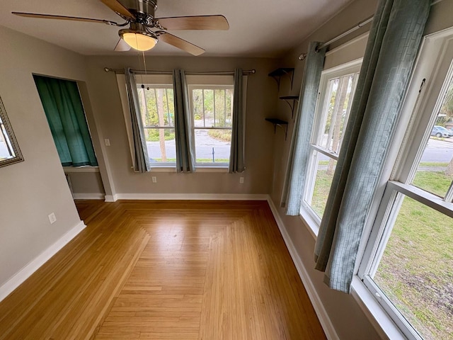 empty room with baseboards, a healthy amount of sunlight, and ceiling fan