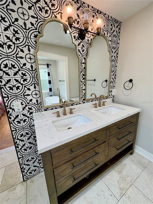 full bathroom with double vanity, baseboards, and a sink