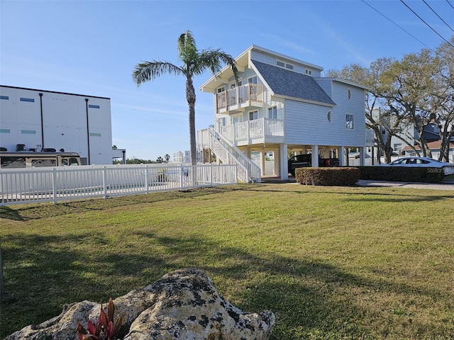 view of yard with stairway, a balcony, and fence