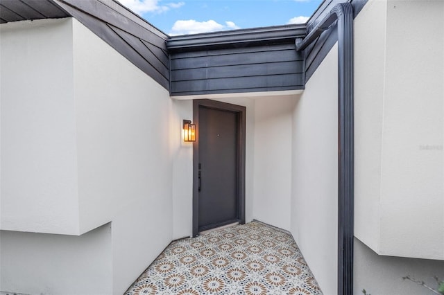 entrance to property featuring stucco siding