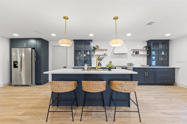 kitchen with open shelves, stainless steel fridge with ice dispenser, visible vents, and light countertops