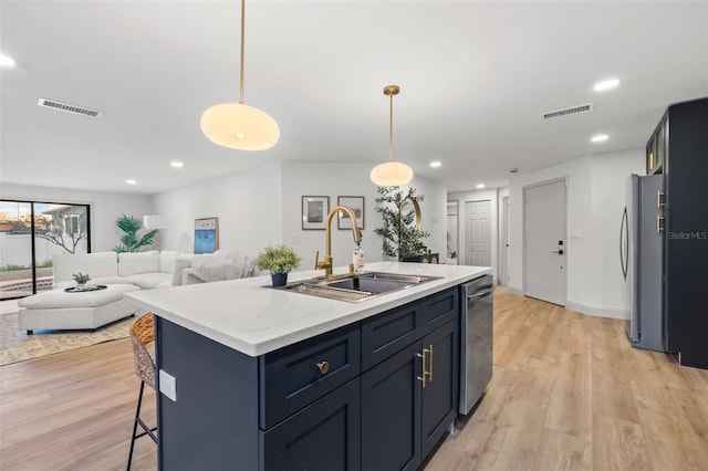 kitchen featuring a sink, stainless steel appliances, light wood-style floors, and visible vents