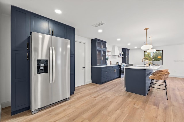 kitchen with visible vents, a sink, appliances with stainless steel finishes, custom exhaust hood, and open shelves