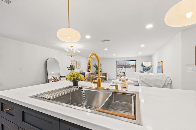 kitchen featuring visible vents, a sink, recessed lighting, light countertops, and hanging light fixtures