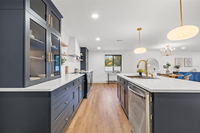 kitchen with visible vents, a sink, light countertops, light wood-style floors, and appliances with stainless steel finishes