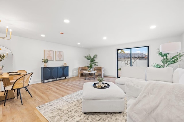 living room featuring recessed lighting, light wood-type flooring, baseboards, and an inviting chandelier