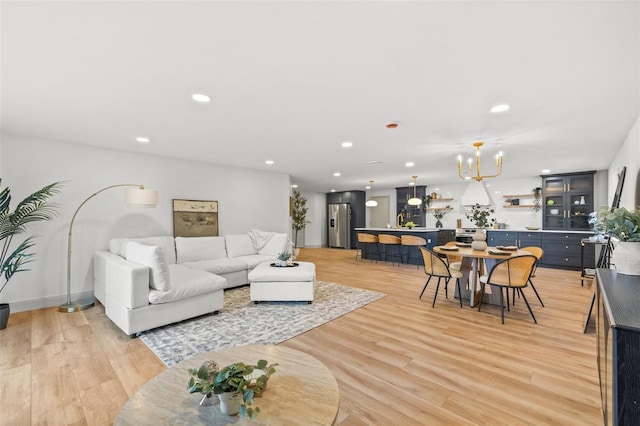 living area featuring recessed lighting, an inviting chandelier, and light wood-style floors