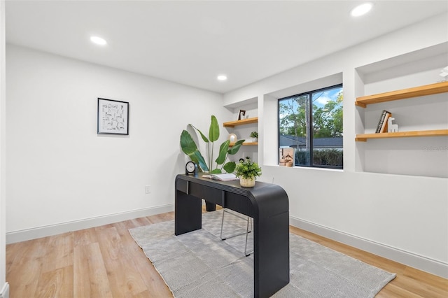 office area featuring recessed lighting, baseboards, built in shelves, and wood finished floors