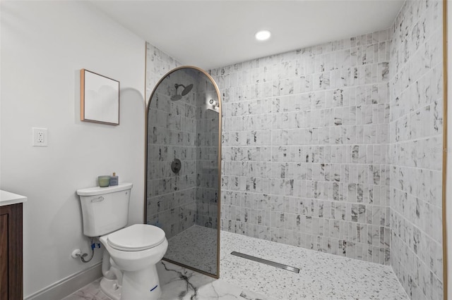 bathroom featuring vanity, toilet, baseboards, and walk in shower