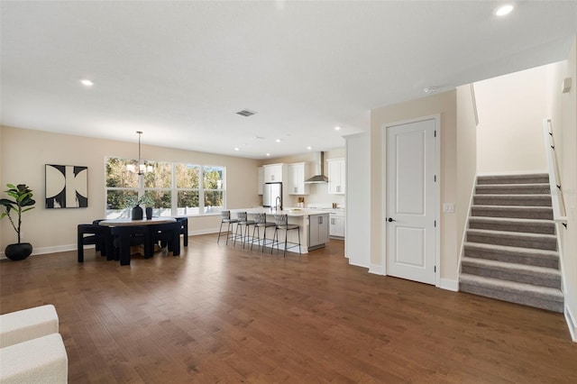 living room featuring dark wood finished floors, stairway, recessed lighting, and a chandelier