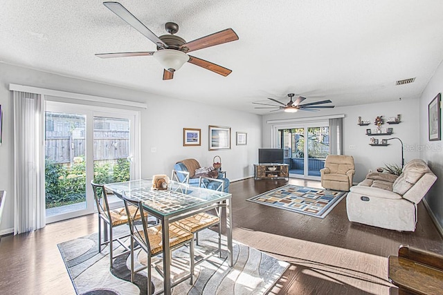 dining area with visible vents, a textured ceiling, a ceiling fan, and wood finished floors