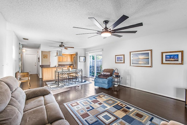 living room with visible vents, a textured ceiling, wood finished floors, and a ceiling fan