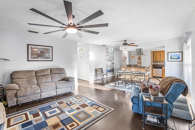 living area with visible vents, baseboards, wood finished floors, a textured ceiling, and a ceiling fan