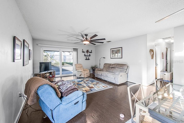 living room with a textured ceiling, wood finished floors, visible vents, and ceiling fan