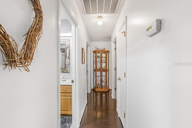 hall featuring dark wood-style floors, visible vents, and a textured ceiling