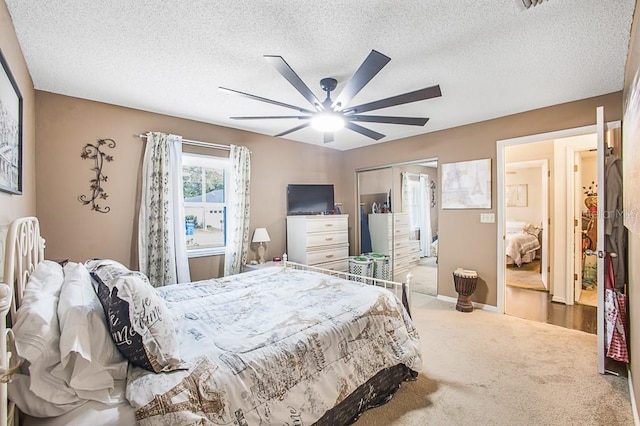 carpeted bedroom with a closet, baseboards, a textured ceiling, and a ceiling fan