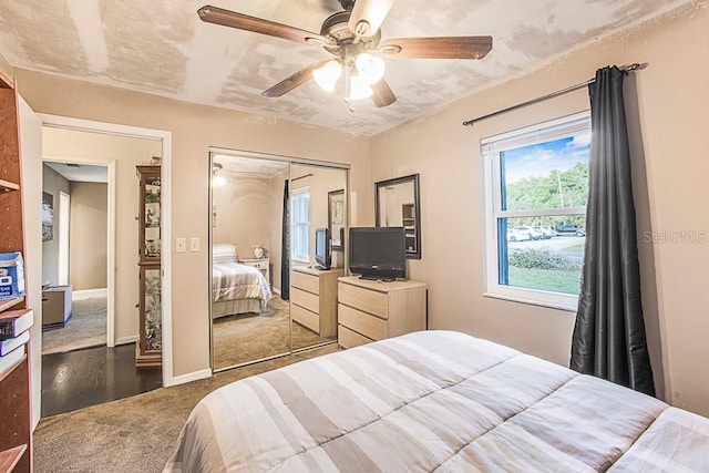 carpeted bedroom with a closet, baseboards, and a ceiling fan