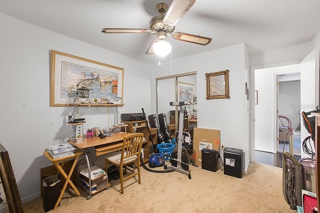 office featuring carpet flooring, a ceiling fan, and a textured ceiling