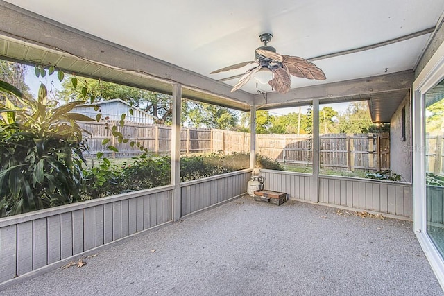 unfurnished sunroom with a ceiling fan