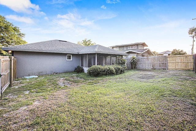 back of property featuring a yard, a fenced backyard, and a shingled roof