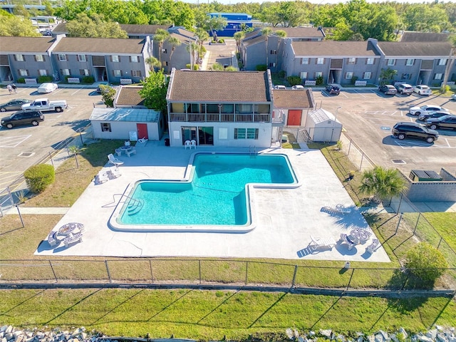 community pool with a residential view, a fenced backyard, and a patio area